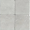 Four square White Pearl and Botticino Beige marble 4X4 tumbled tiles displayed elegantly