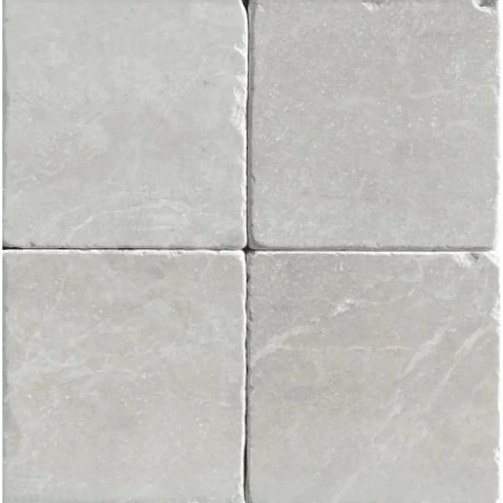 Four square White Pearl and Botticino Beige marble 4X4 tumbled tiles displayed elegantly