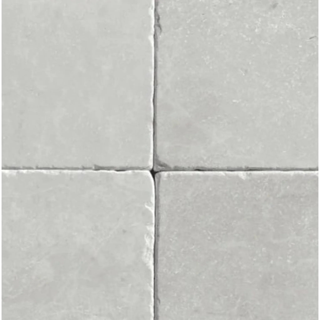 Four light gray square tiles of White Pearl/Botticino Beige Marble 6X6 Tumbled